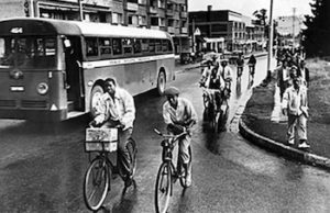 Black people riding bikes next to a bus